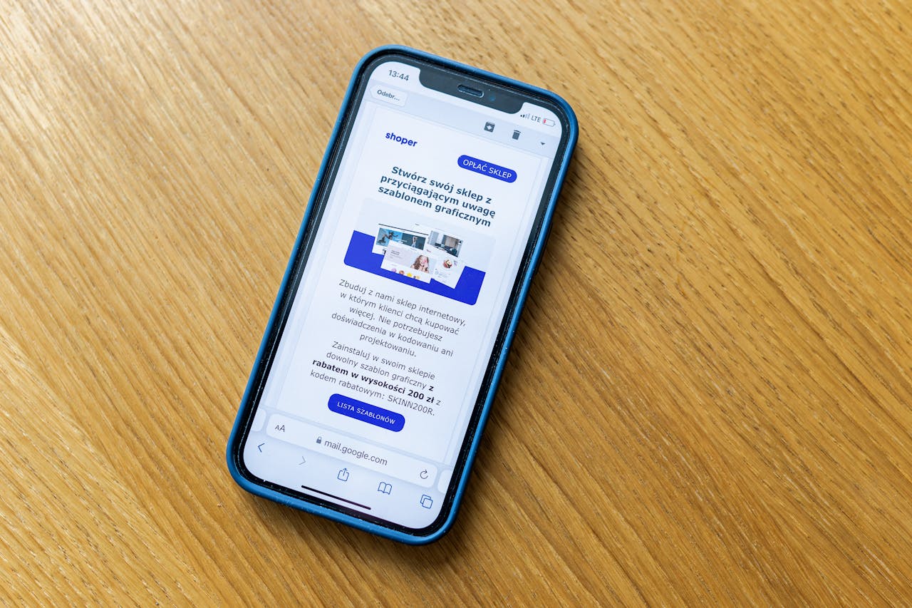 Close-up of a smartphone on a wooden table showing an online shopping webpage.